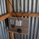 A school trip to Africa with Africa Expedition Support installing the charge controller and junction box in a poor rural home ready for solar power in Kenya